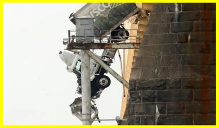 Driver rescued from truck hanging on bridge